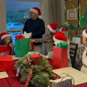 Olimpia Senior Care Christmas Party Passing Gifts to Residents