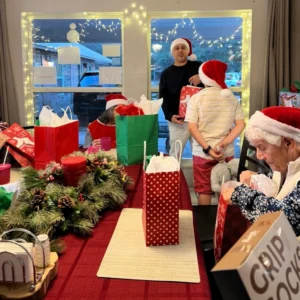 Olimpia Senior Care Christmas Party Passing Out Gifts To Residents